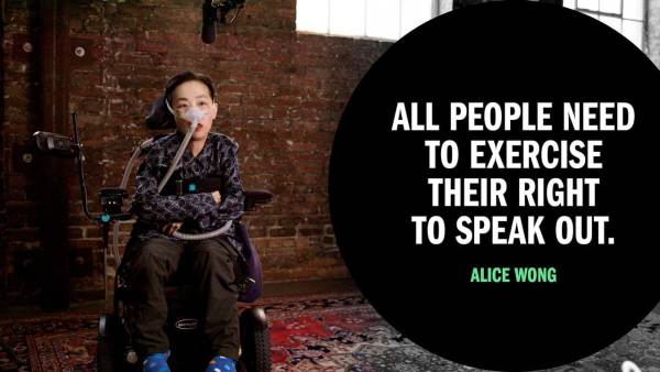 Alice Wong, an Asian American woman in a wheelchair wearing a mask over her nose attached to a tube for a BiPAP machine that helps her breathe. She is wearing a navy striped shirt and dark pants. Next to her is copy in a black circle that reads "All people need to exercise their right to speak out."